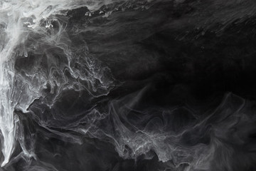 abstract flowing swirls of grey paint on black background