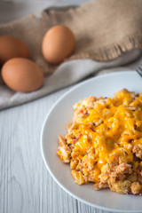 Scramble  Eggs with Cheese on Top in a White Plate 