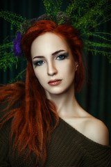 Young red head model is posing with a creative makeup 