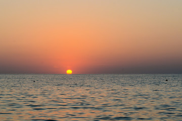 sun and sea merge at sunset