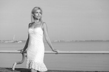 Fototapeta na wymiar young woman by the sea in a white dress