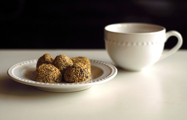 Sesame seed balls or Onde-onde and a cup of drink. Glutinous rice flour stuffed with mung bean paste coated with sesame seeds. Indonesian traditional street food.