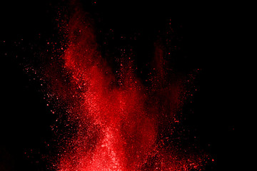 abstract red powder explosion on black background.abstract red powder splatted on black background. Freeze motion of red powder exploding.