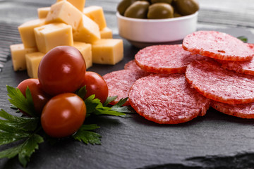 delicious sliced salami on a stone plate wooden background