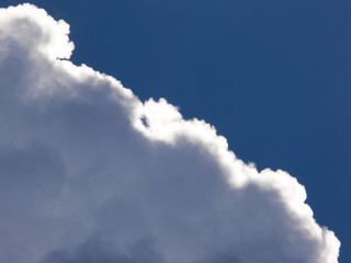 Against the blue sky the cloud is illuminated by the sun
