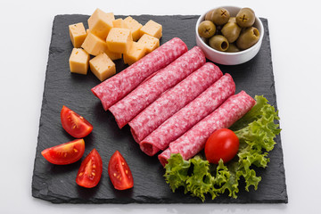 delicious sliced salami on a stone plate white background