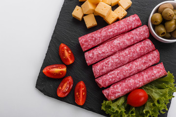 delicious sliced salami on a stone plate white background
