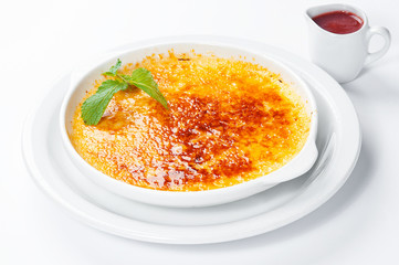 French dessert creme brulee with berry sauce and mint