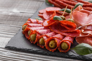 Cold smoked meat plate on a rustic wooden background