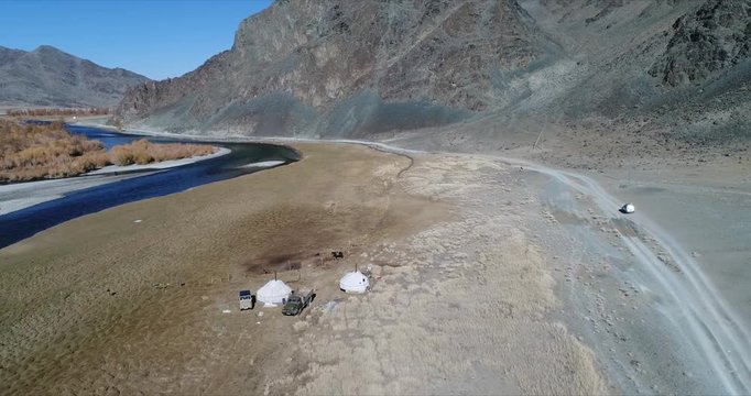 4k 60 fps Mongolia Aerial view of Altai desrt track with 4x4 driving - flying over ger tent in wild