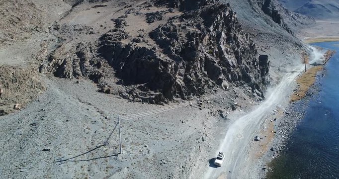 4k 60 fps Mongolia Aerial view of Altai desrt track with 4x4 driving - driving along river