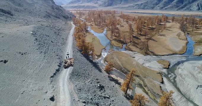 4k 60 fps Mongolia Aerial view of Altai track with 4x4 behind sheep herd - flying to side view