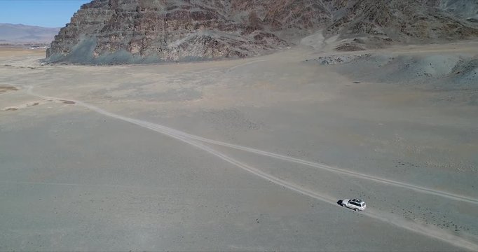 4k 60 fps Mongolia Aerial view of Altai desrt track with 4x4 driving - getting into view from right