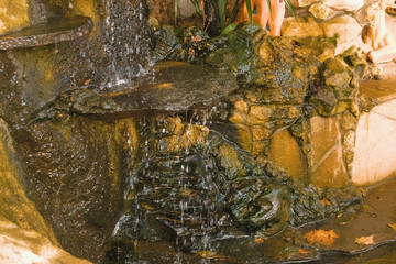 Decorative small waterfall at the fountain in rocks.