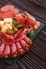 Cold smoked meat plate on a rustic wooden background