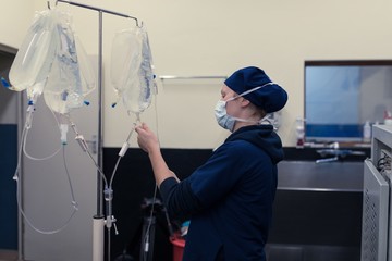 Female surgeon checking iv saline drop