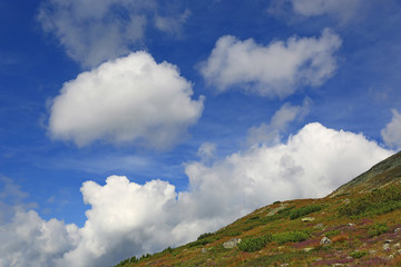 nice clouds over mountain slope