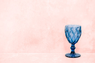 Blue textured wine glass on a concrete background.