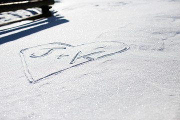 Initials in love heart on the snow