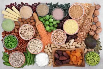 Fototapeta na wymiar Health food with high protein content with legumes, vegetables, dried fruit, grains, supplement powders, almond yoghurt, seeds & nuts. Super food high in fibre, vitamins & antioxidants. Top view.