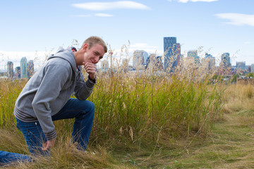 Naklejka na ściany i meble young man kneeling in grass