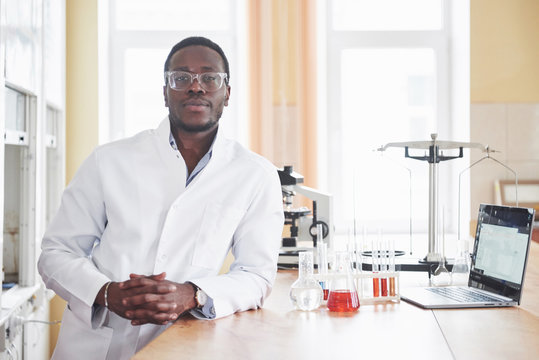 An African American worker works in a laboratory conducting experiments.