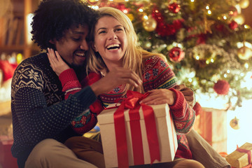 Obraz na płótnie Canvas Cheerful boy and girl exchanging Christmas presents .