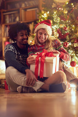 Fototapeta na wymiar Happy boy and girl exchanging Christmas presents .