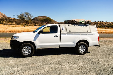 Pickup 4x4 car on road trip has a stop at picnic rest area in desolate nature landscape in the...