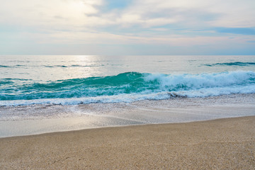 Waves with foam hitting sand on the tropical beach texture.