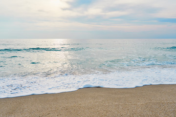 Waves with foam hitting sand on the tropical beach texture.