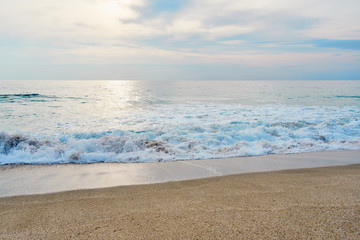 Fototapeta na wymiar Waves with foam hitting sand on the tropical beach texture.