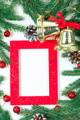 Fototapeta na wymiar New Year's background. Christmas jewelry on fir-tree branches, gold spheres, garlands and a red frame for a photo or an inscription. White backgroun