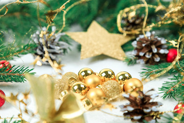 New Year's background. Christmas jewelry on fir-tree branches, gold spheres, garlands, a big gold star of an ishishka on branches. White background