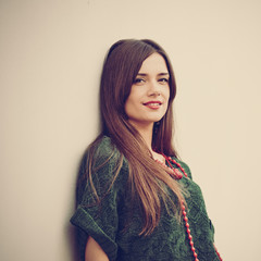 Portrait of young beautiful fashionable brunette girl posing, image with warm vintage toning and...