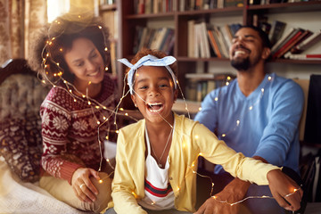 Fototapeta na wymiar happy family – parents and little daughter playing together for the Christmas holidays.