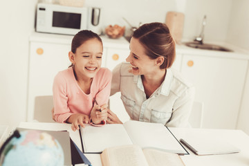 Fototapeta premium Mom Helps Daughter To Do Homework In The Kitchen.