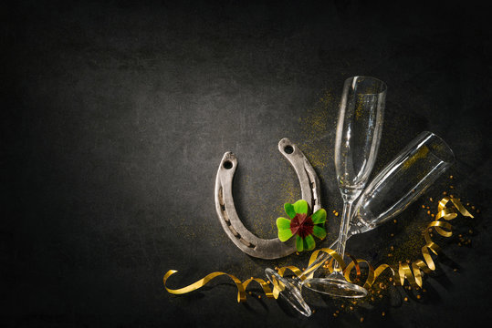 Two champagne glasses with a horseshoe and shamrock as lucky charm