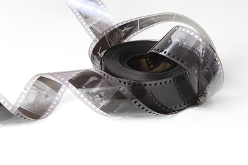 Old photographic film in a roll on a light background. The concept of history, home archives, memorable dates. Selective focus, close-up.