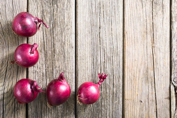 spanish onions on old rustic wood table background, top view