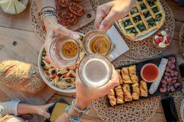 toast with friends, dinner on the terrace in joy, aperitif at the end of summer, aperitif with beer and pretzels, joy and festivities