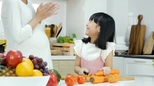 Little girl help her mother preparing food at kitchen. Mother teaching her daughter to cooking. People with lifestyle and healthy concept.