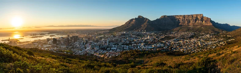 Foto op Plexiglas Tafelberg Zeldzaam wolkenloos zicht op Kaapstad en de Tafelberg tijdens zonsopgang.