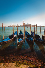 Fototapeta na wymiar Beautiful view of the moored gondolas and the Cathedral of San Giorgio Maggiore on the background, on an island in the Venetian lagoon, Venice, Italy