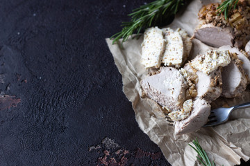 Roast pork meat with onion, garlic and rosemary served with nuts butter on brown stone table. 