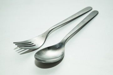 One spoon and fork on white background