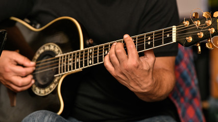 Fototapeta na wymiar Closeup of a musician playing the guitar live at a greek restaurant