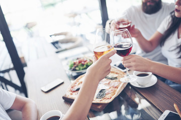 Friends got together by table with delicious food with glasses of red wine to celebrate a special occasion