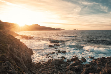 Sunset and rough sea on the coast of Corsica