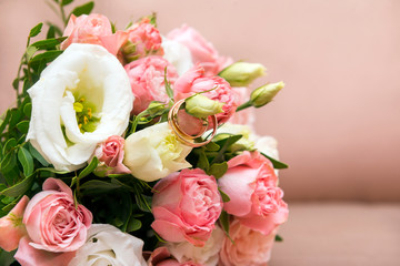 wedding bouquet of pink roses with gold wedding rings